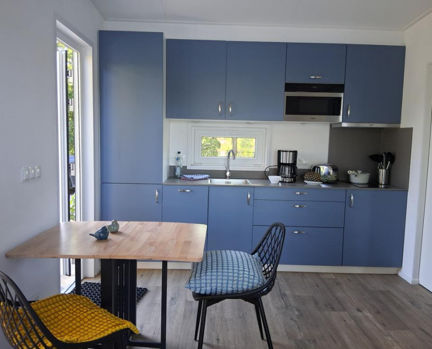 Moderne Ferienwohnung-Küche mit blauer Küchenzeile und Essplatz – hell und voll ausgestattet