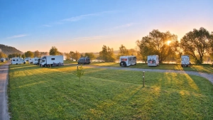 Wohnmobilstellplatz am Weserbogen bei Sonnenaufgang mit warmem Morgenlicht und Blick auf den Fluss.